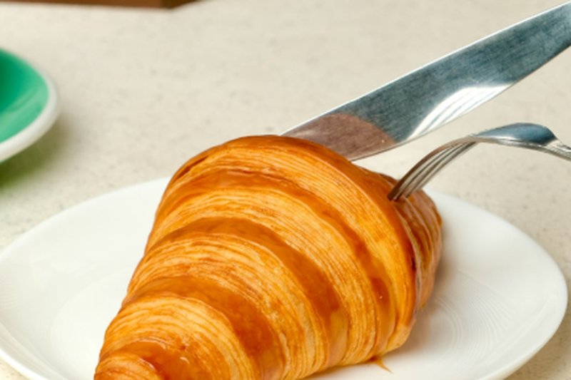 Sepotong croissant butter di atas piring putih